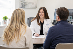 Fertility doctor explaining IVF vs IUI treatment options to couple during consultation