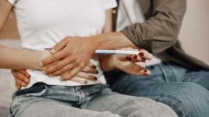 Couple holding a pregnancy test while researching IVF cost and fertility treatment options in Louisville, Kentucky.